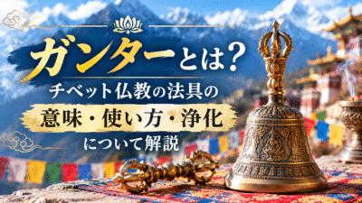 チベット仏教の法具ガンターと金剛杵を描いた画像。チベットの山々や寺院を背景に、ガンターの意味・使い方・浄化について解説する文字が入っている。